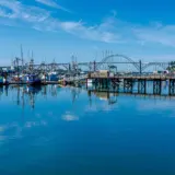 Newport Oregon bayfront with fishing boats and Yaquina Bay Bridge — Newport Oregon seafood plant fire