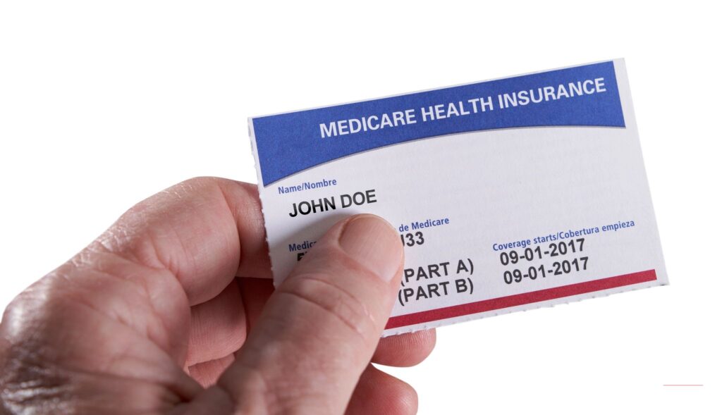 Close-up of a hand holding a U.S. Medicare Health Insurance card (sample card shown for illustration) — no Trump Medicare $90 payment checks for seniors have been issued yet