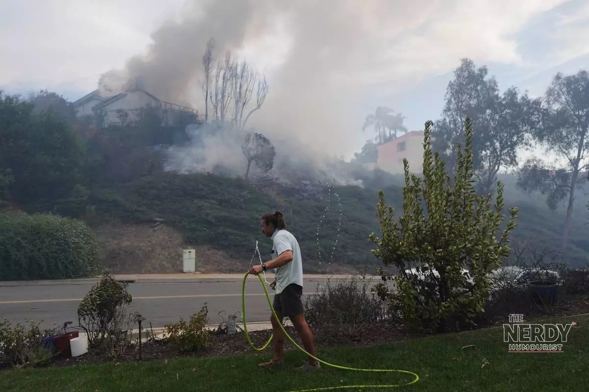 Norte Fire resident wets down property with garden hose in San Juan Capistrano