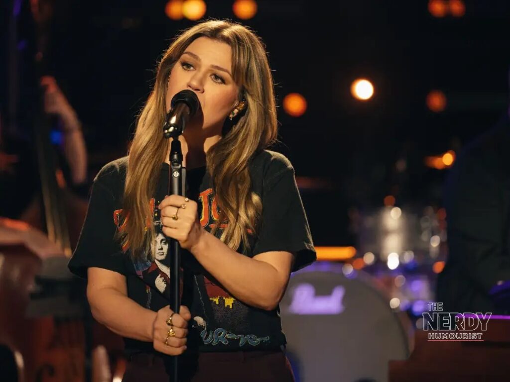 Kelly Clarkson performing a Kellyoke song on her talk show stage during the Kelly Clarkson Art of Play controversy.
