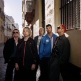 Fontaines D.C. posing in a sunlit Spanish street, the era of the Fontaines D.C. Dopamine Chamber album
