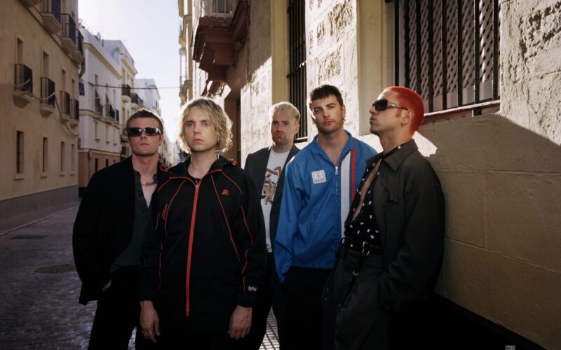 Fontaines D.C. posing in a sunlit Spanish street, the era of the Fontaines D.C. Dopamine Chamber album
