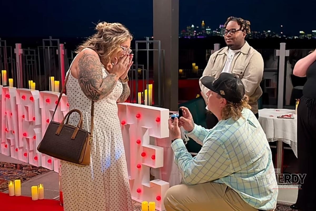 Darrin Kitchens on one knee proposing to Pumpkin engaged on an Atlanta rooftop