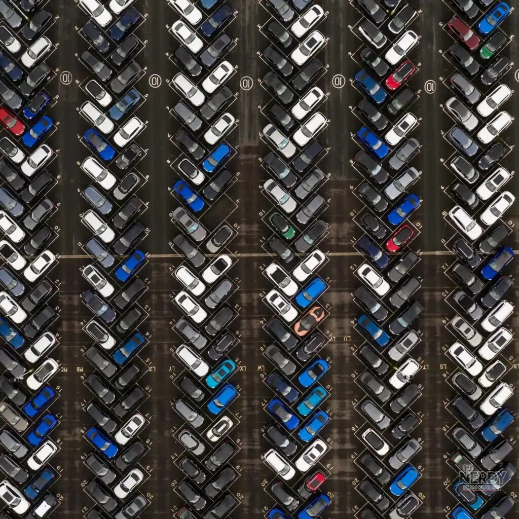 Aerial view of rows of new cars in a lot as gasoline cars market share shifts toward electric vehicles