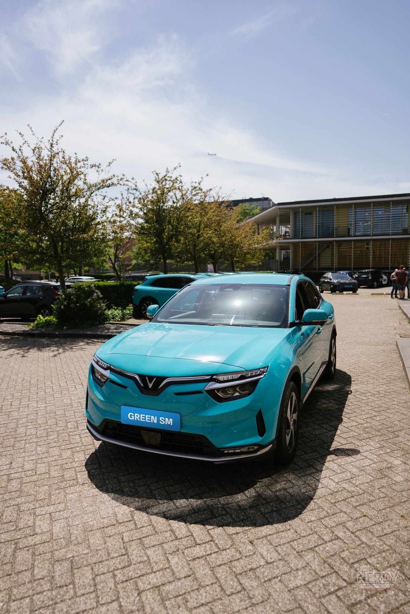 Green SM electric taxi: a teal VinFast VF 8 wearing Green SM branding
