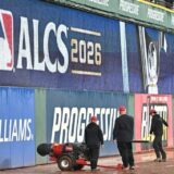 Grounds crew working the soaked warning track at Progressive Field after ALCS Game 4 was postponed by rain
