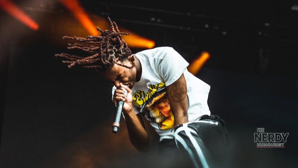 Playboi Carti performing on stage — footage showed him watching from his vehicle during the ComplexCon brawl; he is not implicated