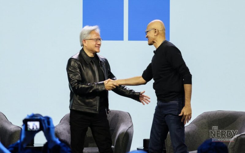 Microsoft CEO Satya Nadella and Nvidia CEO Jensen Huang shake hands on stage at the Surface Laptop Ultra price reveal event
