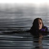 Jane Levy in an official still from the River trailer, treading water at night in the Blumhouse slasher