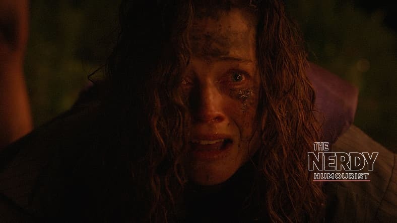 A terrified sibling in the River trailer, lit by firelight during the Blumhouse slasher's night attack