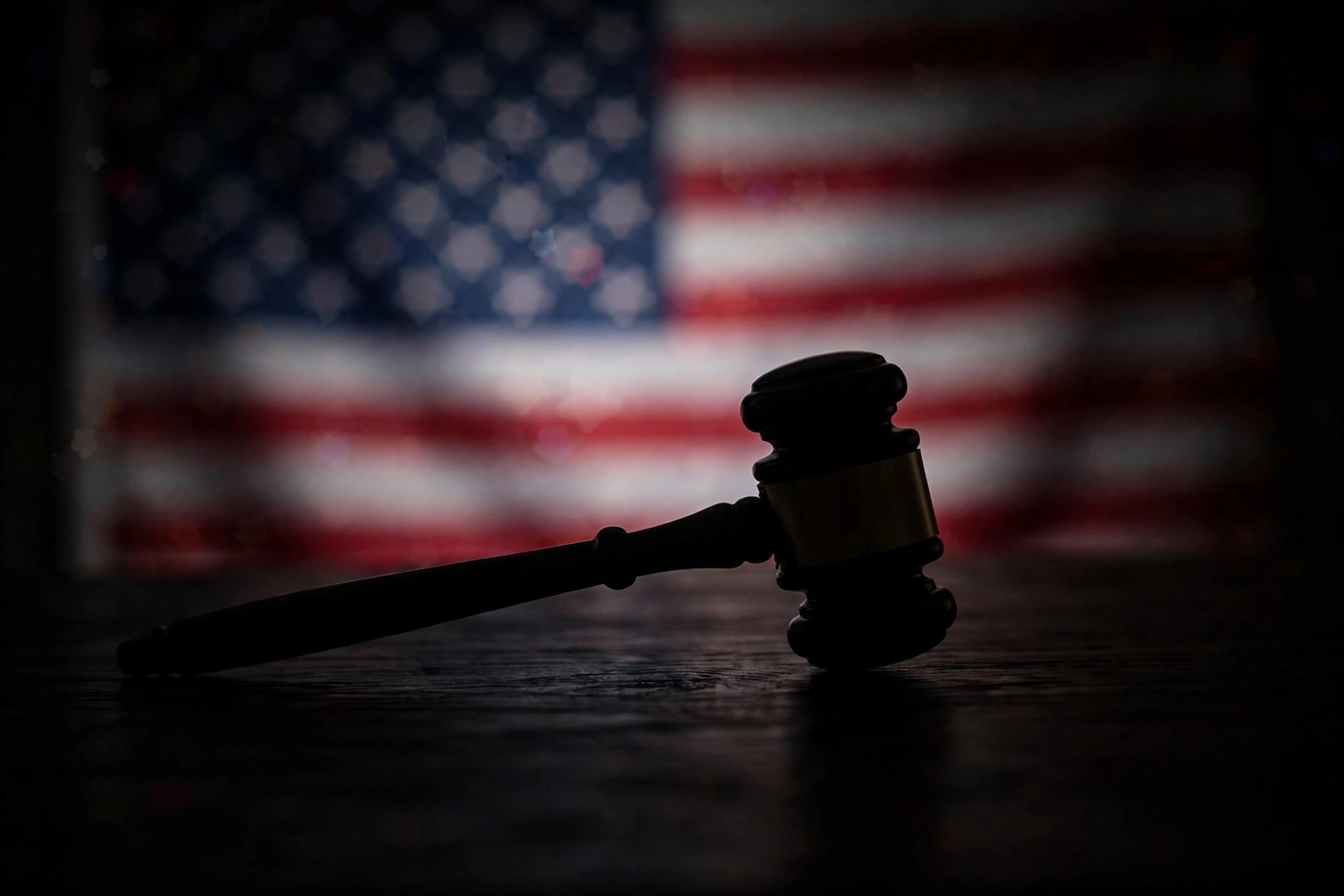 Gavel silhouette on dark desk with blurred flag for Supreme Court immigration detention Trump ruling