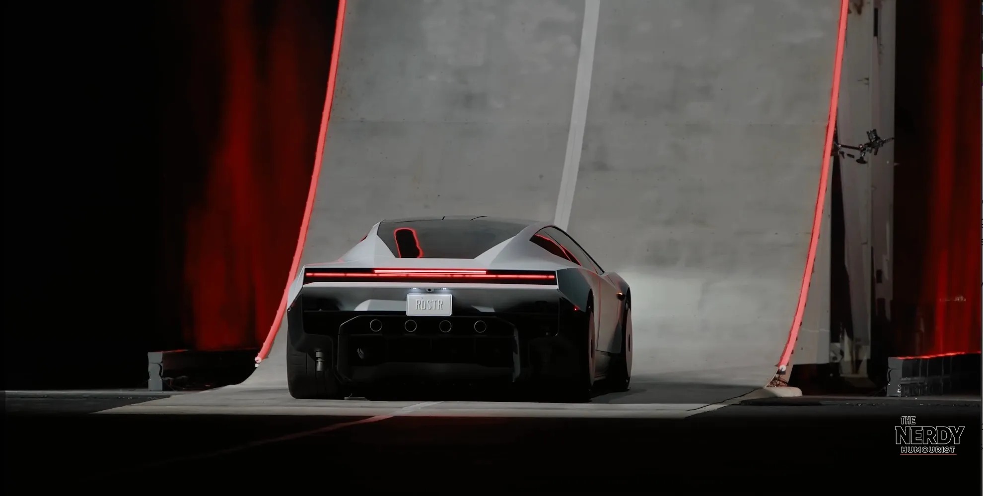 Rear view of the Tesla Roadster with an RDSTR license plate facing the giant halfpipe ramp at the Tesla Roadster unveil demonstration
